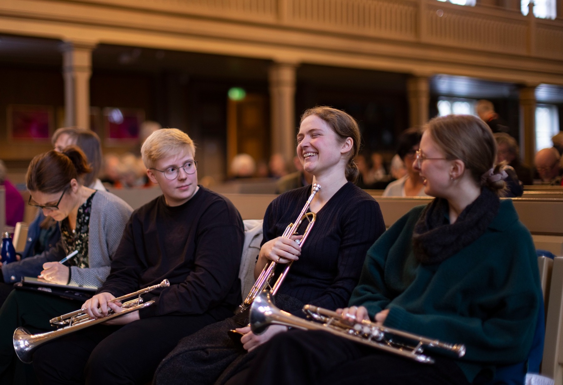 Tre musikere i kirkebenken med sine instrumenter